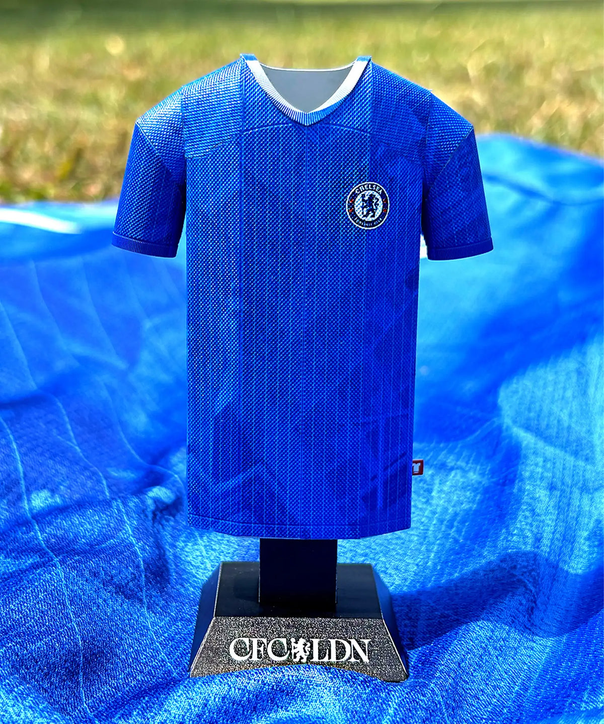 Blue sports jersey on a mannequin with a logo against a blue background