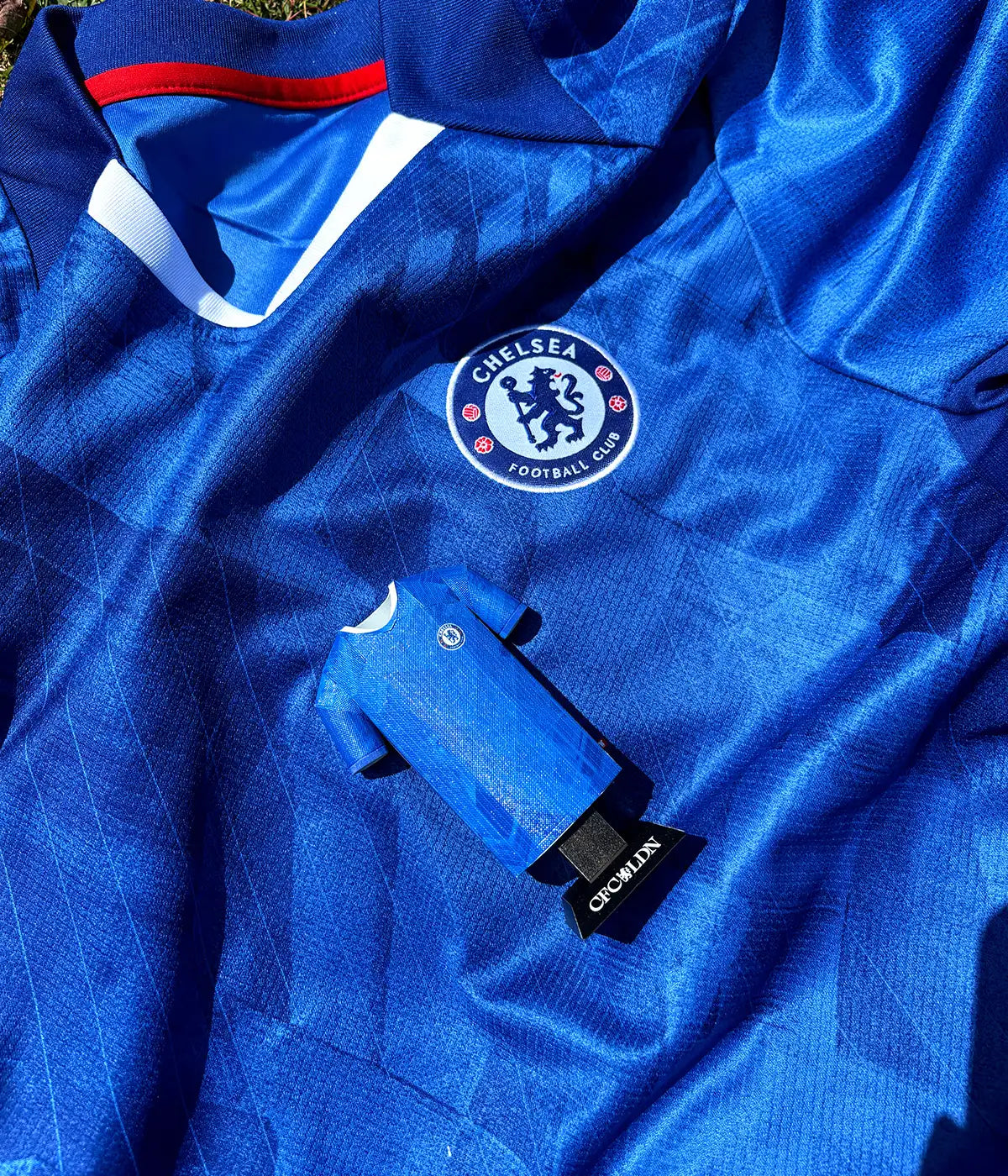 Blue sports jersey with a prominent logo on a matching background